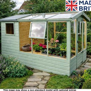 A small green garden potting shed with glass panels and plants inside. The shed has a light green exterior with a glass roof and walls.