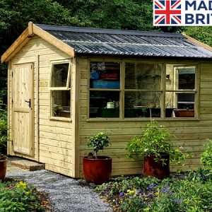 A wooden garden potting shed with a green roof and plants around it. The shed has a door and windows.