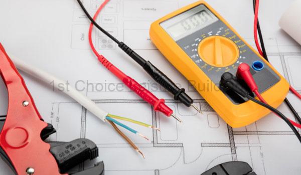 Home 39 A digital multimeter and test leads on a blueprint. The tools are used for electrical testing.