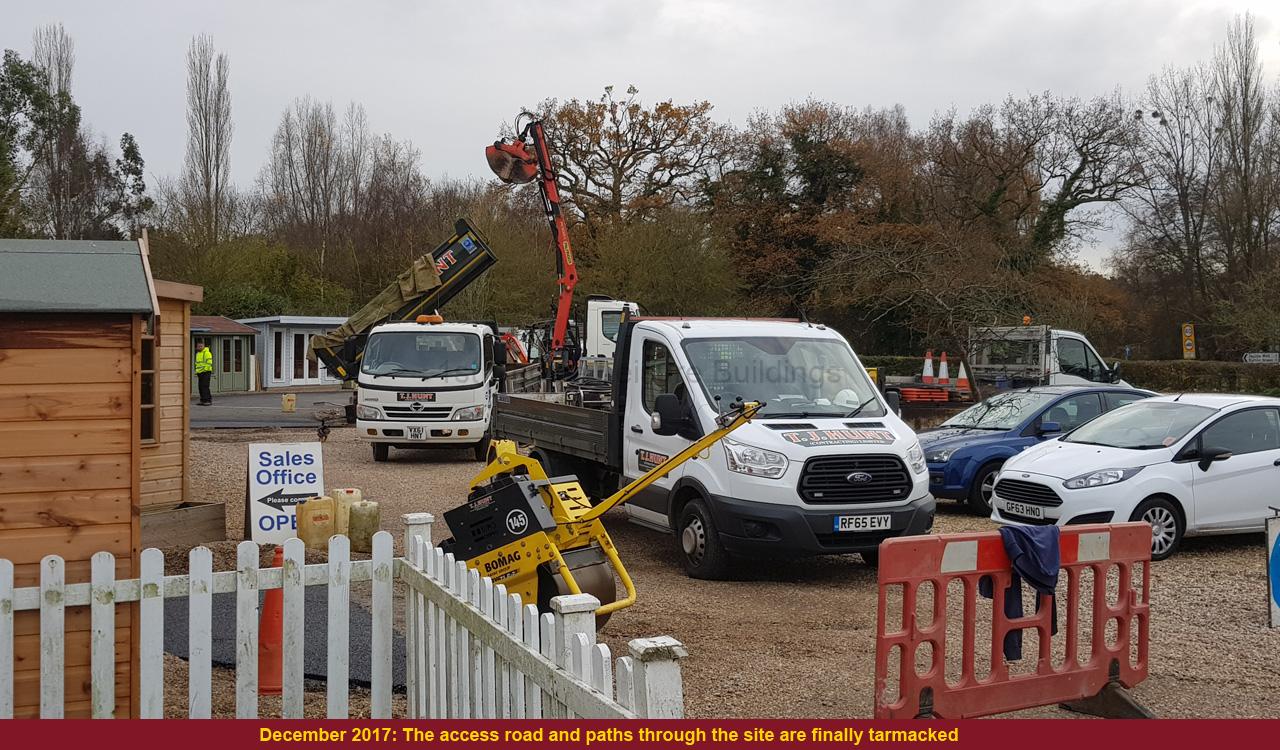 Construction site with vehicles and buildings Construction site with vehicles and buildings. A white van and truck are parked on a gravel lot.
