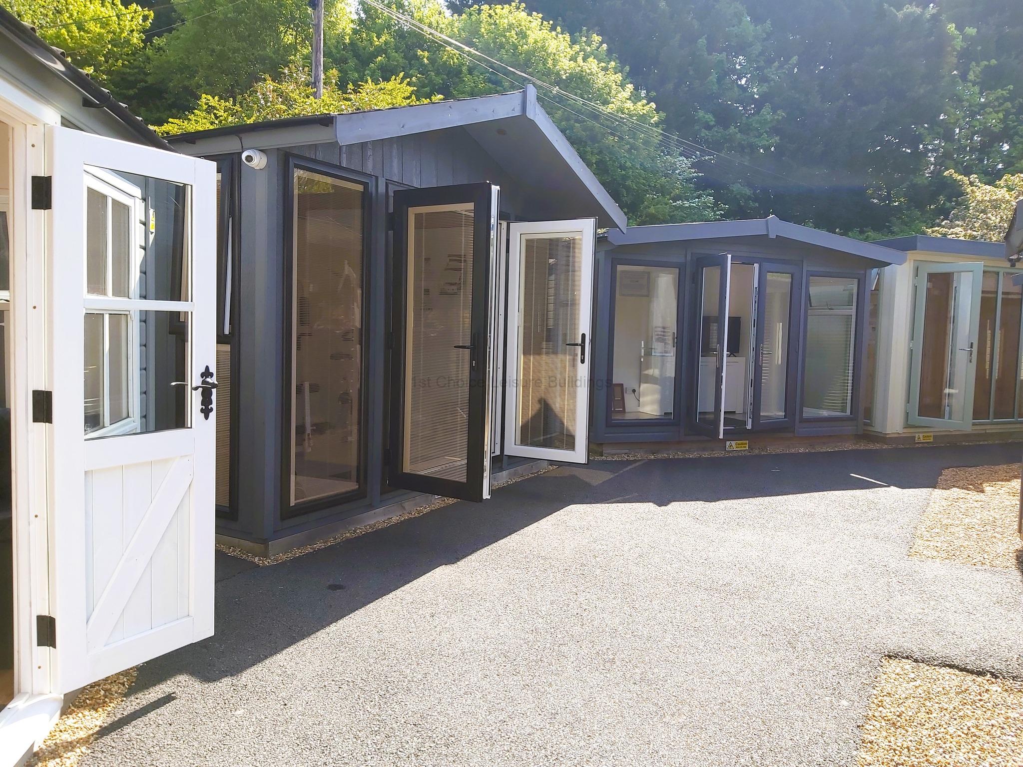 Garden buildings with open doors on display A row of garden buildings with open doors