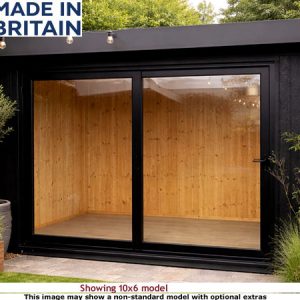 A modern black Royal Denham Garden Room with large windows and wooden interior, surrounded by lush greenery and flowers.