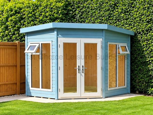 Blue corner wooden summer house with white double doors and side windows on a paved patio.