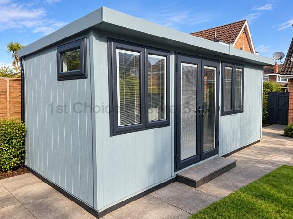Larg2 20ft x 8ft garden room with dark-framed windows and glass doors on a paved patio.