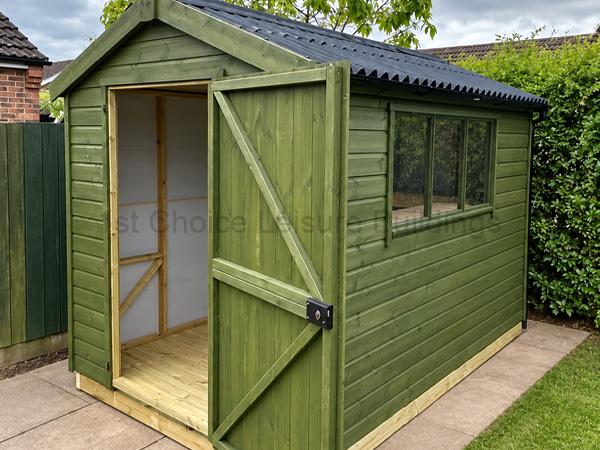 Green wooden garden shed with sloped dark roof, open door, and side window.
