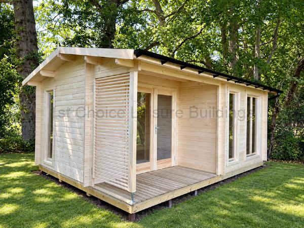 Pale timber log cabin with tall windows and a half-glazed door, installed in a spacious green garden.